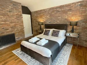 a bedroom with a large bed and a brick wall at 'The Loft' in Yeovil