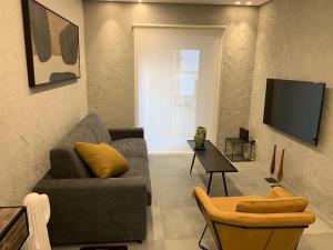 a living room with a couch and a tv at Duomo House in Caltanissetta