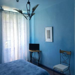 een slaapkamer met een bed, een stoel en een laptop bij Auberge Magnette in Audes