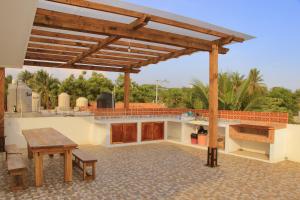 a patio with a wooden pergola and a table at La Aurora in Puerto Escondido