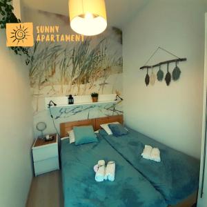 1 dormitorio con cama con chanclas en Sunny Apartament, en Darłowo