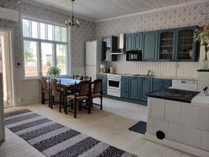 a kitchen with blue cabinets and a table and chairs at Willa Viktor in Kristinestad +40 photos