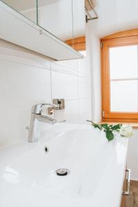 lavabo blanco en un baño con ventana en Hiša Bepina en Koper