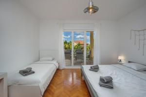 two beds in a room with a view of a patio at APP BLUE, SELCE in Selce