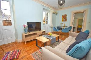 a living room with a couch and a tv at Roses Apartment in Corfu city centre in Corfu