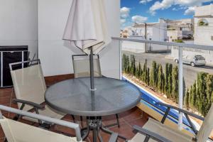 een tafel en stoelen op een balkon met uitzicht op een straat bij Fantastic 2 bedroom fully furnished modern apartment in walking distance to all amenities in Villamartin