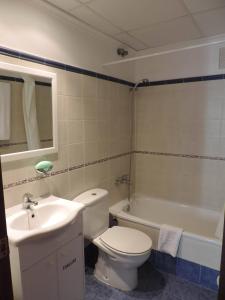 a bathroom with a toilet and a sink and a tub at Hotel Costa San Antonio in Cullera