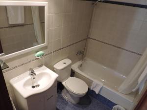 a bathroom with a toilet and a sink and a tub at Hotel Costa San Antonio in Cullera