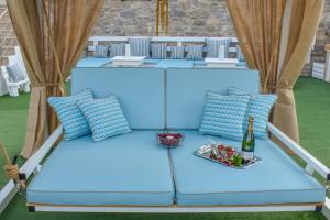 Una cama azul con almohadas y una botella de vino. en FTELIA LUXURY STUDIO ''QUATTRO'' en Megali Ammos