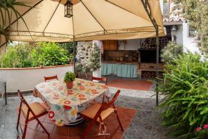 patio ze stołem, krzesłami i parasolem w obiekcie Bodega Goyo w mieście Puntallana