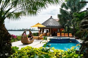 a couple sitting in a swing by the pool at a resort at Hotel Boutique Playa Canela Ecuador in Salinas