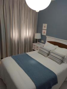 a bedroom with a bed with a blue and white blanket at La Placita, Sanxenxo in Sanxenxo