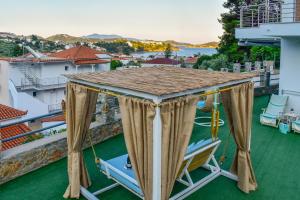 a balcony with a gazebo and chairs on a roof at FTELIA LUXURY STUDIO ''QUATTRO'' in Megali Ammos