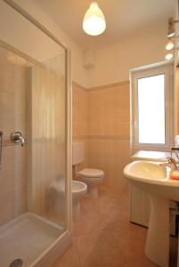 a bathroom with a sink, toilet and shower at Appartamenti family & MTB in Finale Ligure
