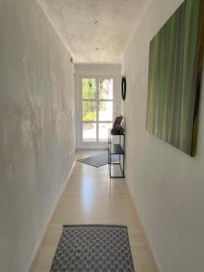 a hallway with a rug on the floor and a window at Black Forest Guest Stay in Pfalzgrafenweiler