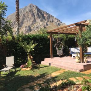einen Hinterhof mit einer Terrasse mit einem Berg im Hintergrund in der Unterkunft Holiday Home Baia Cofano in Custonaci