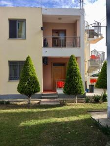 ein Haus mit zwei Bäumen davor in der Unterkunft Shyqi Apartments in Velipojë
