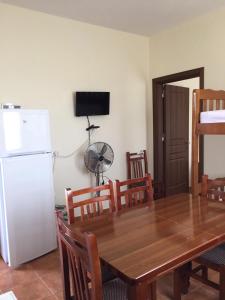 ein Esszimmer mit einem Tisch und einem weißen Kühlschrank in der Unterkunft Shyqi Apartments in Velipojë