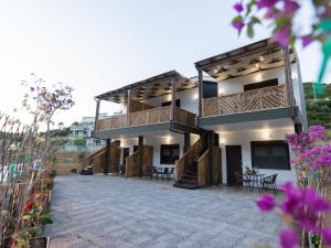 a house with a balcony and a patio at MAD'S Villas in Nea Peramos