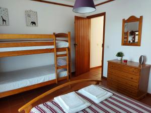 a bedroom with two bunk beds and a mirror at Space Monte da Rosa in Vila Nova de Milfontes