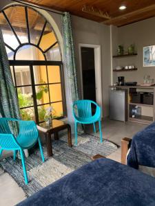 a living room with blue chairs and a large window at Sarah's Place San Andres in San Andrés