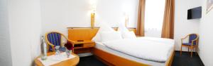 a hotel room with a bed and two chairs at Pension Helma in Bad Neuenahr-Ahrweiler