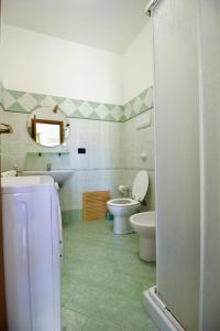 a bathroom with a sink and a toilet and a mirror at Salina in Trappeto