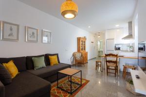 ein Wohnzimmer mit einem Sofa und einem Tisch in der Unterkunft Atico-Solarium CITY Hall by Cadiz4Rentals in Cádiz