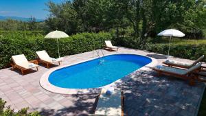 basen z 2 leżakami i parasolem w obiekcie Apartment in Silo - Insel Krk 39710 w mieście Šilo