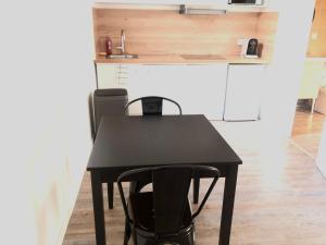 een zwarte tafel met twee stoelen in een keuken bij Libourne centre in Libourne
