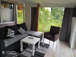 a living room with a couch and a table and a window at Lenilenii Bungalows in Jajce