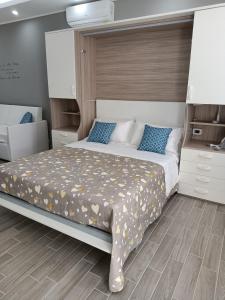 een slaapkamer met een groot bed met blauwe kussens bij Monolocale da Andrea in Custonaci