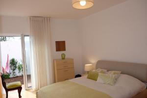 1 dormitorio con 1 cama, vestidor y ventana en A Casa Do Terraco en Ponta Delgada