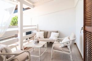 a balcony with chairs and a table and a couch at Amazing View Beach Villa in Santa Maria