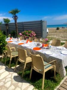 a long table with chairs and a table with the beach at Inn Arazny in Gudauta