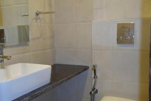 a bathroom with a sink and a toilet and a shower at Hotel Saffron Inn in New Delhi +36 photos