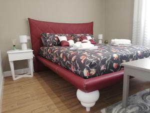 un letto rosso con testiera rossa in una stanza di Belvedere 75 a Napoli