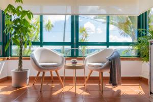 two chairs and a table in front of a large window at La Casiña in A Coruña