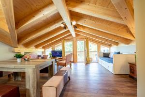 una sala de estar con techos de madera y una mesa de madera. en Haus Ludwig Alpenkrähe, en Garmisch-Partenkirchen
