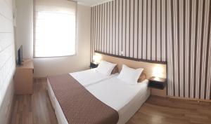 Schlafzimmer mit einem Bett mit weißer Bettwäsche und einem Fenster in der Unterkunft Obzor Beach Resort Apartment G-109 in Obsor