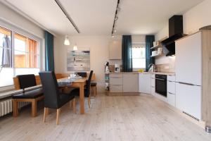 a kitchen and dining room with a table and chairs at Haus Heckenrose Whg 5 EG in Kellenhusen