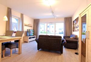 a living room with a couch and a table and chairs at Merlin 3 Waldstr 20 h in Kellenhusen