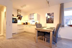 a kitchen and dining room with a table and chairs at Merlin 3 Waldstr 20 h in Kellenhusen