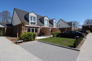 a house with a car parked in a driveway at Merlin 3 Waldstr 20 h in Kellenhusen