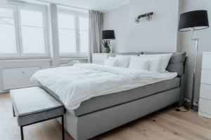 a white bedroom with a large bed and a chair at 2-Zimmer City Apartment 57m² mit King Size Bett und Küche in Münster