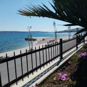 einen Zaun an einem Strand neben dem Wasser in der Unterkunft Apartman Figaro sa dva kupatila uz more i plažu s pogledom na Split in Kaštela