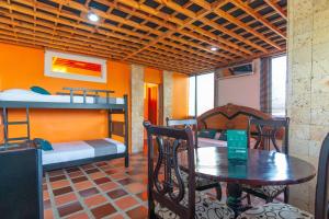 a room with two bunk beds and a table and chairs at Ayenda Brisas del Caribe in Santa Marta