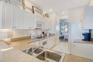 a kitchen with white cabinets and a sink at Lely-Best of Beautiful Naples Free golf from May 15-October 15 in Naples