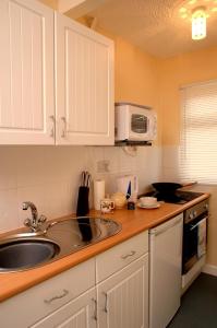 a kitchen with a sink and a microwave at Seaside Cottage in Clacton-on-Sea