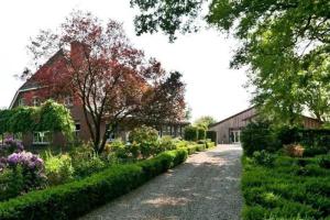 una entrada que conduce a una casa con jardín en Karibu Het Voorhuis 2 tot 6 persoons luxe slaapkamers met een mooie woonkeuken en Daarle